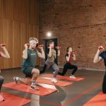 Indoor group workout session with dumbbells focusing on strength and fitness.